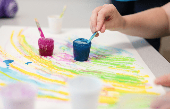 close-up of hand painting with colored watercolors