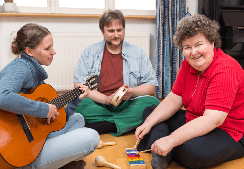 three adults playing percussion instruments and guitars