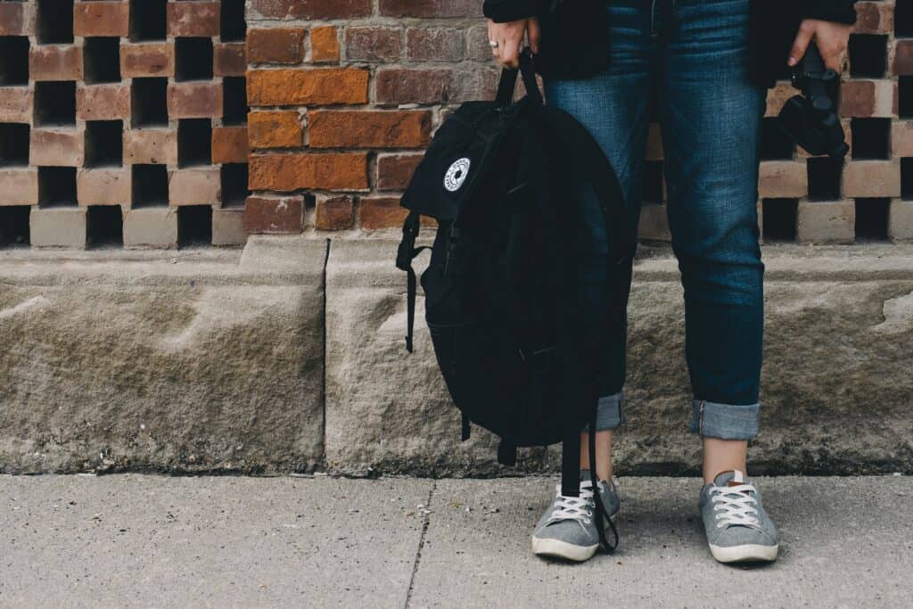 A child standing, holding their backpack ready for back to school. Healing with music H h music 